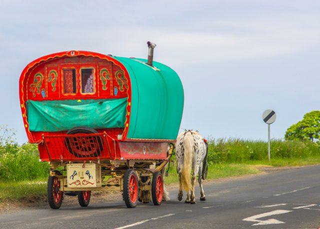 Old Romani horse-drawn wagon on a rural British road.