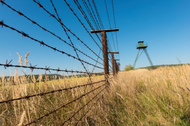 This section of the Iron Curtain is the only preserved section of the border defenses in the Czech Republic. Last 200 meters with lookout tower in distance. Low angle view.