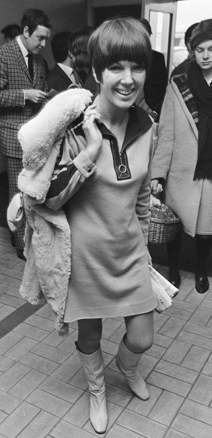 Mary Quant in 1966, with a mini-dress of her own creation, which she wears with a sheepskin coat and go-go boots. Author Anefo CC BY-SA 3.0