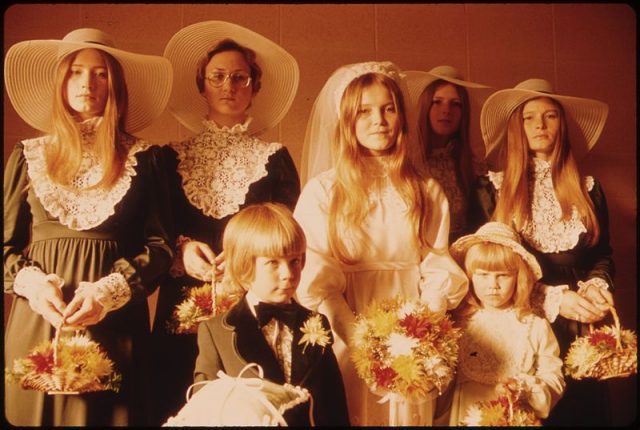 Photograph of a bride and her attendants in New Ulm, Minnesota, 1974. The ladies’ lace detail and  page-boy’s suede collar were “in” in the 70s.
