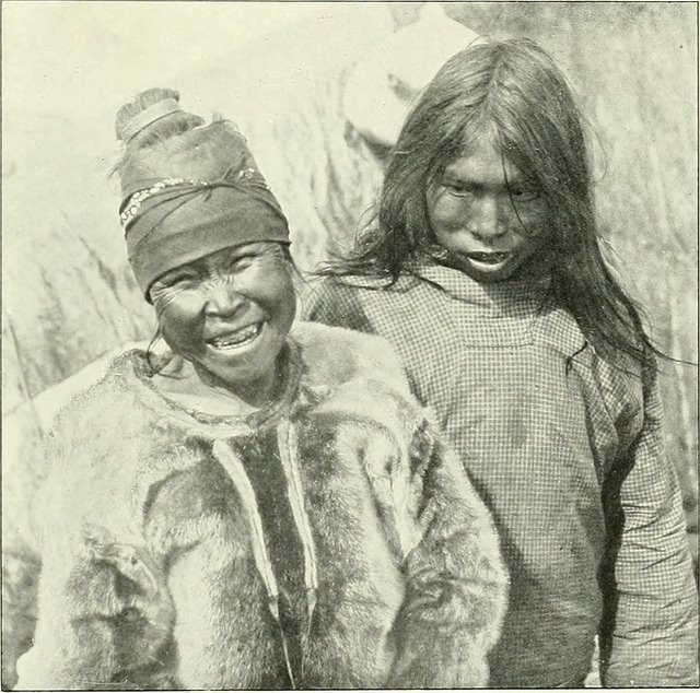 Ammassalik Eskimo. The woman on the left is wearing a fur jacket for the cold.