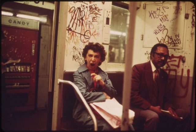 Subway passengers aboard NYC subway, 1970s.