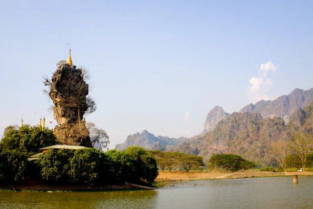 Kyauk Kalap Temple is the famous Buddhist landmark with a golden pagoda on top of the rock in the middle of the lake at Hpa An, Myanmar.