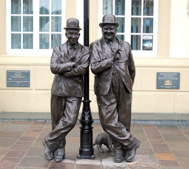 Statue of Stan Laurel and Oliver Hardy outside the Coronation Hall Theatre, Cumbria, England (Laurel’s birthplace). Photo by Hilton Teper CC BY-SA 3.0