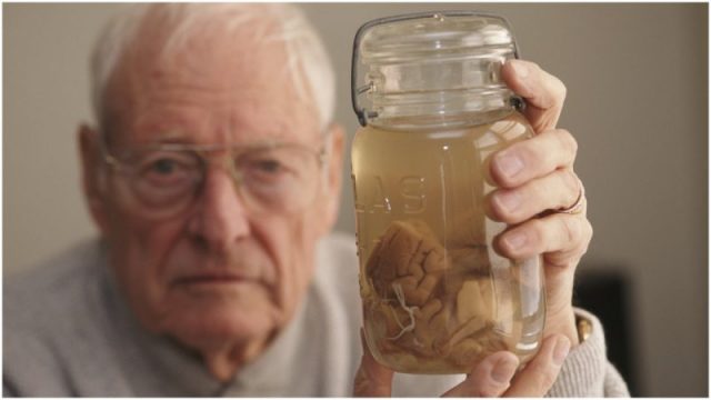 Pathologist Thomas Harvey (1912 – 2007) holds the brain of theoretical physicist Albert Einstein in a jar, Kansas, 1994. Harvey performed the autopsy on Einstein in 1955, and retained parts of the brain for scientific study. Photo by Michael Brennan/Getty Images