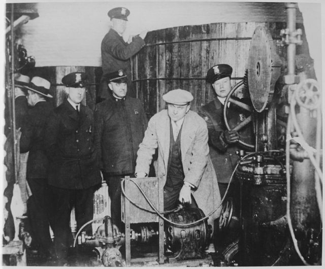 Detroit police inspecting equipment found in a clandestine underground brewery during the prohibition era