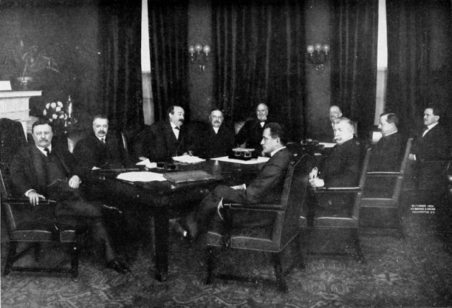 Group portrait of the cabinet of President of the United States Theodore Roosevelt (at far left). Left to right in back of table: George B. Cortelyou, Charles Joseph Bonaparte, x, James Wilson, Truman Handy Newberry. Left to right in front of table: x, Luke Edward Wright, George von Lengerke Meyer, James Rudolph Garfield