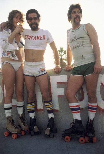 LOS ANGELES – DECEMBER 28: A woman and two men taking a break from roller skating on December 28, 1979 in Venice Beach, CA. (Photo by Waring Abbott/Getty Images)