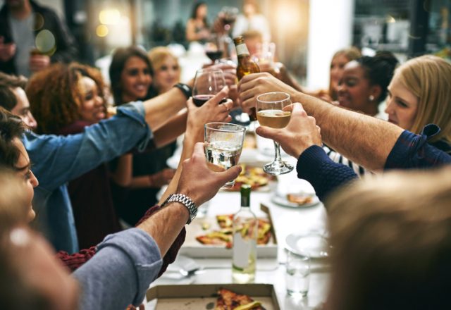 young friends toasting during a dinner party at a restaurant