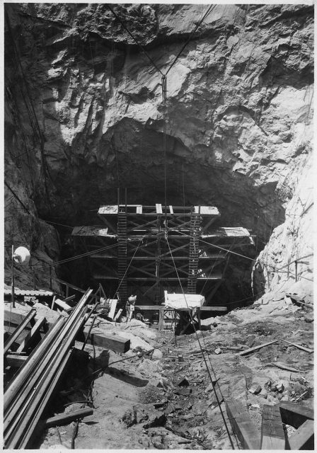 Trimming jumbo being lowered into inclined spillway tunnel on Nevada side.