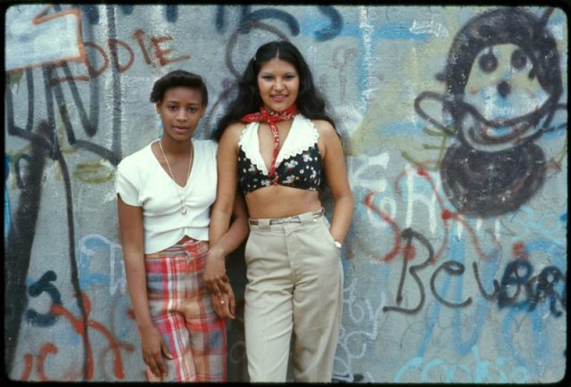 Two girls pose in front of a wall of graffiti in Lynch Park in Brooklyn, N.Y., in June 1974.
