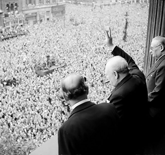 Winston Churchill waving to crowds in Whitehall, London on the day he confirms that the war with Germany was over