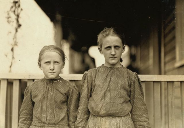 Two young girls posing for a photograph