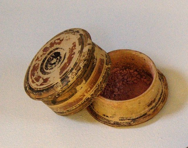 Corinthian pyxis with a red make-up powder. Found in a tomb from the 5th century BC.