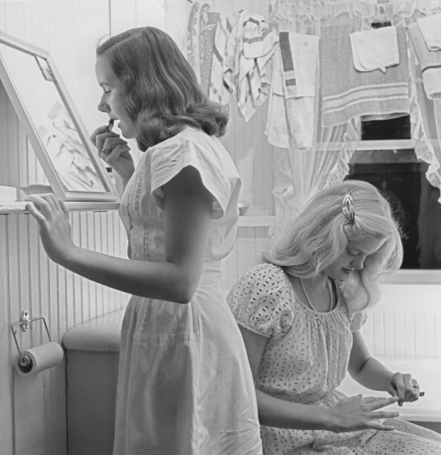 Two teenage girls getting ready in a bathroom c. 1960. Photo by Archive Photos/Getty Images