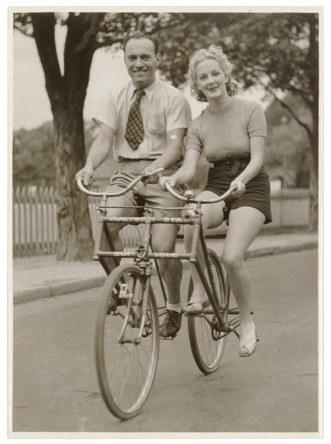 Man and woman on a Malvern Star abreast tandem bicycle, c. 1930s, by Sam Hood
