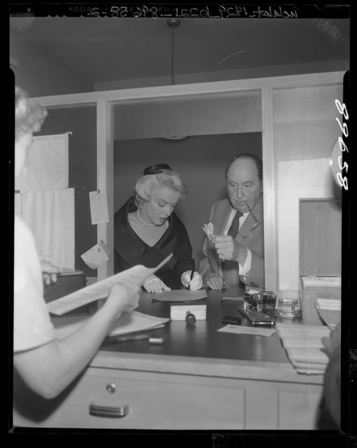 Marilyn Monroe signing divorce papers with celebrity attorney Jerry Giesler.