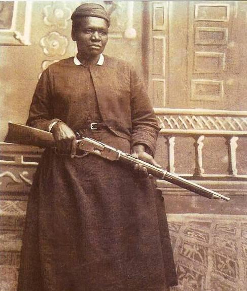 Sepia-tone photograph of Mary Fields, holding a rifle.