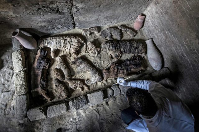 An Egyptian archaeologist cleans mummified cats during the demonstration of a new discovery made by an Egyptian archaeological mission through excavation work at an area located on the stony edge of King Userkaf pyramid complex in Saqqara Necropolis, south of the capital Cairo, on November 10, 2018. Photo by KHALED DESOUKI / AFP/Getty Images