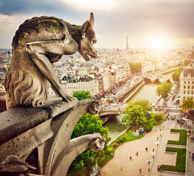 Gargoyle sitting on Notre Dame Cathedral and looking on Paris cityscape