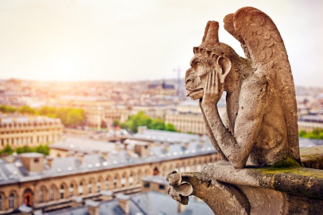 Gargoyle sitting on Notre Dame Cathedral contemplating the Paris cityscape