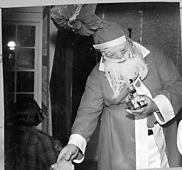 Santa Claus hands out gifts, Rodanthe, NC, January 1938. Photo by State Archives of North Carolina.
