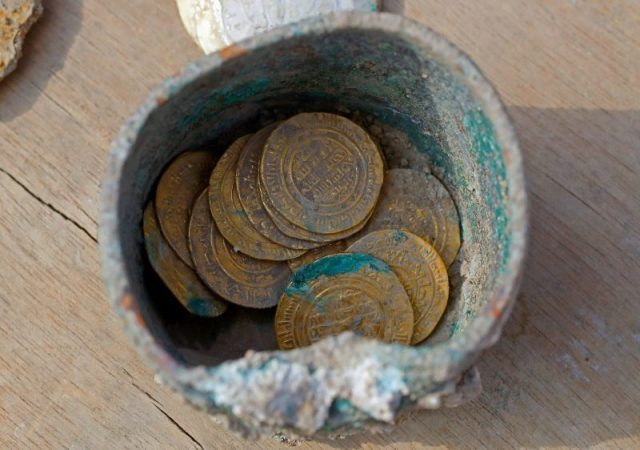 A picture taken on December 3, 2018, shows ancient gold coins recently uncovered at an excavation site in the Israeli Mediterranean town of Caesarea. – A treasure of 24 rare gold coins consisting of 18 Fatimid dinars, which were the standard local currency during that time (909-1171), as well as six are Byzantine coins, which include five dating to the era of Byzantine Emperor Michael VII Doukas (1071-1078), was recently uncovered in Caesarea. (Photo by JACK GUEZ / AFP/GETTY IMAGES)