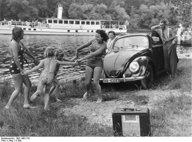 KdF Propaganda: “A family playing by a river with a KdF-Wagen and radio receiver”. Photo by Bundesarchiv, Bild 146II-732 / Unknown / CC-BY-SA 3.0