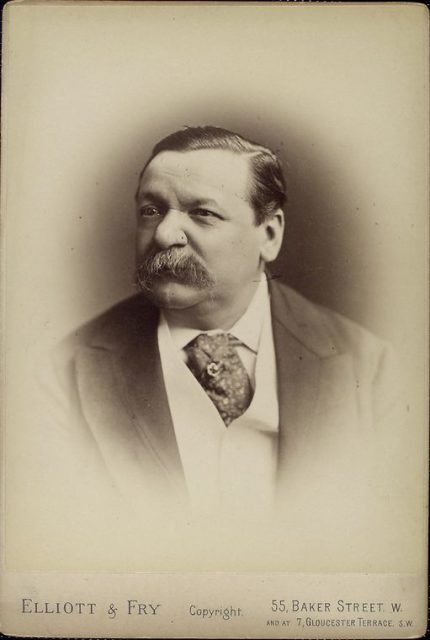 Portrait photo of British journalist George Augustus Sala wearing an ascot tie.