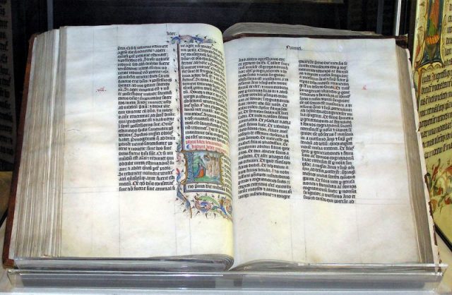 A Bible handwritten in Latin, on display in Malmesbury Abbey, Wiltshire, England. The Bible was written in Belgium in 1407 AD, for reading aloud in a monastery.
