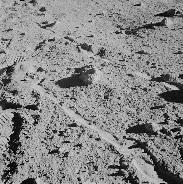 The two moon-exploring crew men of the Apollo 14 lunar landing mission photographed and collected the large rock pictured just above the exact center of this picture.