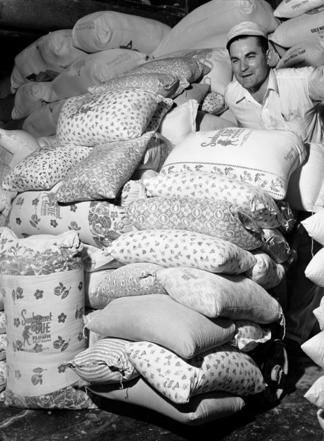 Warehouse worker wheeling colorfully printed flour sacks which housewives use to make dresses because the labels wash out, at Sunbonnet Sue flour mill. Photo by Margaret Bourke-White/The LIFE Picture Collection/Getty Images