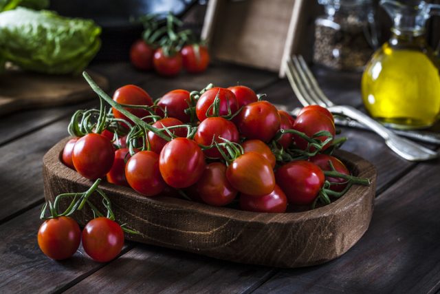 Fresh organic cherry tomatoes in a wooden tray