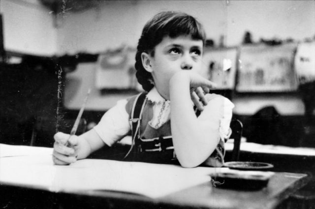 Young girl seated at desk in classroom in Chicago, Illinois. Photography by S. Kubrick.