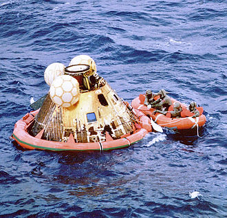 Columbia floats on the ocean as Navy divers assist in retrieving the astronauts