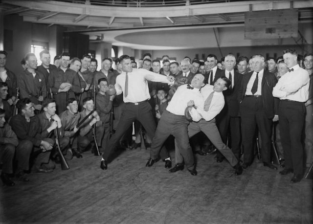 Heavyweight boxer Jack Dempsey mock-punching Houdini (held back by lightweight boxer Benny Leonard)