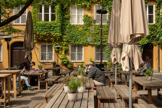 Augsburg, Germany – May 18,2018: Art students sit at a table in the Fuggerei housing complex drawing