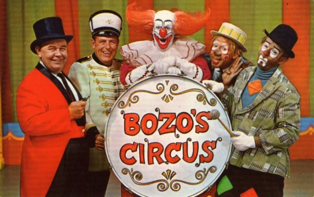 “Postcard photo of the main cast of Chicago’s Bozo’s Circus. From left: Ringmaster Ned (Ned Locke), Mr. Bob (bandleader Bob Trendler), Bozo (Bob Bell), Oliver O. Oliver (Ray Rayner), Sandy (Don Sandburg)”