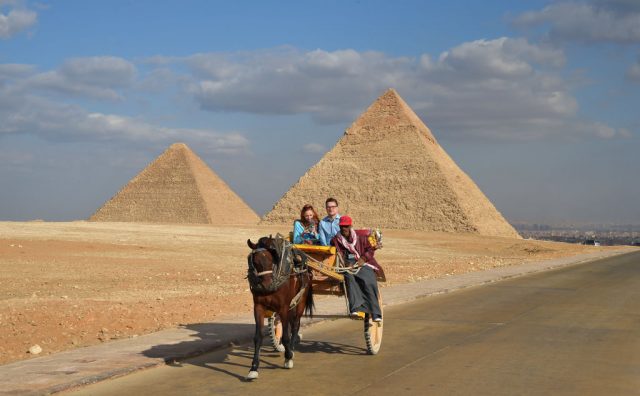 An Egyptian drives a horse-drawn cart with a couple of tourists at the Giza pyramids necropolis on the southwestern outskirts of the Egyptian capital Cairo on December 29, 2018, with the pyramids of Khafre (or Chephren, R) and Khufu (or Cheops, L) seen in the background. Getty Images