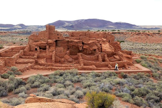 Couple walks through ancient Wupatki Pueblo Indian ruins in Wupatki National Monument Arizona. (Photo by: Education Images/Universal Images Group via Getty Images)