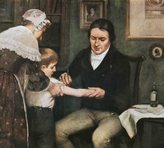 Dr. Edward Jenner performing his first vaccination against smallpox on James Phipps, a boy of eight, oil on canvas by Ernest Board.