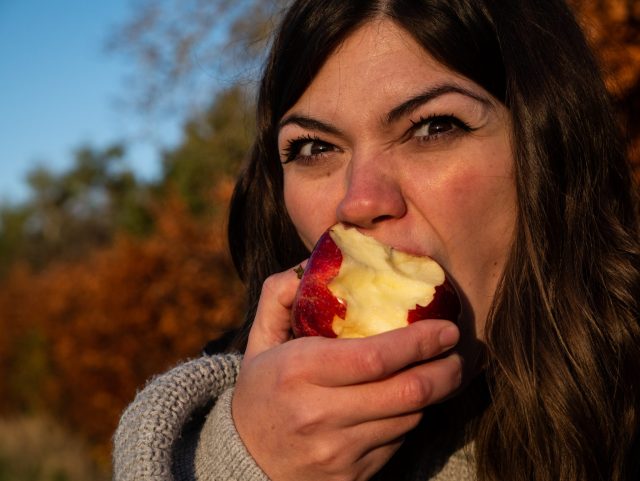 woman biting intensely into an apple