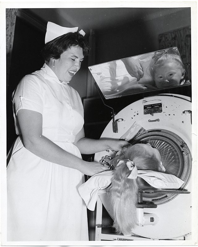 Nurse treating child in an iron lung
