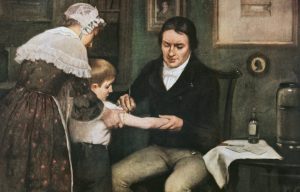 Dr. Edward Jenner performing his first vaccination against smallpox on James Phipps, a boy of eight, oil on canvas by Ernest Board.