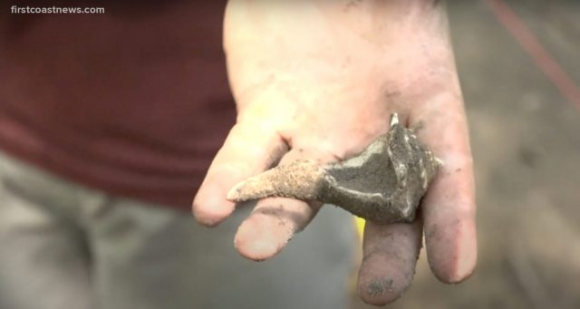Dirt covered Indigenous artifact in someone's hand
