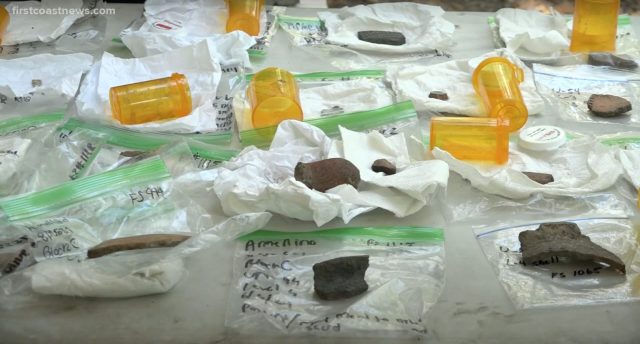 Indigenous artifacts placed on a table amongst plastic lunch bags and medication containers