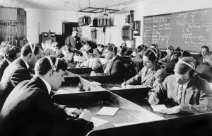 Students learning Morse code at the first Marconi Wireless School in the United States in New York, 1916. The new law after the Titanic disaster requiring operators to be on board all ocean liners assures the men of a position when they graduate.