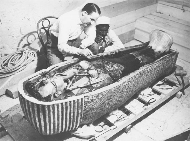 Archaeologist Howard Carter (1874-1939) examining the third mummy-shaped sarcophagus, 1922.