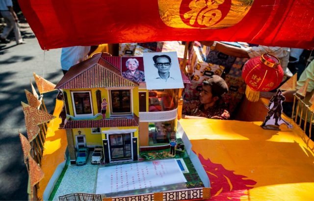 Offerings of paper houses and other replicas of wealth as they place it on a boat to be burnt at Hong San Koo Tee temple in Surabaya, to mark the Hungry Ghost Festival.