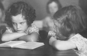 circa 1950: Two little girls enduring a dull lesson at primary school.